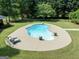 Up-close view of private in-ground pool with lounge chairs in large backyard at 1040 Rock Creek Rd, Social Circle, GA 30025