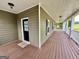 Expansive covered porch with wood flooring and exterior door at 1040 Rock Creek Rd, Social Circle, GA 30025