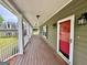 Long covered porch with wood flooring and views of the lawn at 1040 Rock Creek Rd, Social Circle, GA 30025