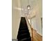 View of the black staircase with wooden handrail and chandelier lighting at 1040 Rock Creek Rd, Social Circle, GA 30025