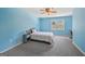 A bright bedroom with blue walls features a ceiling fan and a cozy reading nook at 612 Longer Dr, Peachtree City, GA 30269