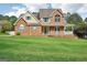 Charming brick and siding home with a well-manicured lawn, a covered porch, and traditional details at 612 Longer Dr, Peachtree City, GA 30269
