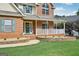 Close-up of a welcoming front porch with brick accents, a decorative wreath, and manicured landscaping at 612 Longer Dr, Peachtree City, GA 30269