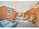 Cozy angled living room with orange walls, modern furnishings, and natural light at 612 Longer Dr, Peachtree City, GA 30269