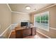 Bright office space with a wooden desk, hardwood floors, and a large window providing ample natural light at 612 Longer Dr, Peachtree City, GA 30269