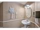 Cozy half bath features an elegant pedestal sink and owl macrame wall art at 612 Longer Dr, Peachtree City, GA 30269