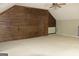 Bonus room with a rustic wood accent wall, plush carpet, and modern ceiling fan at 695 Frog Rd, Locust Grove, GA 30248