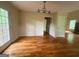 View of the dining room showcasing hardwood floors, a modern light fixture, and entry to adjacent rooms at 695 Frog Rd, Locust Grove, GA 30248