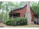 Charming home featuring a covered porch, brick chimney, and surrounded by lush greenery at 695 Frog Rd, Locust Grove, GA 30248