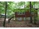 Exterior view of home surrounded by trees, featuring a back deck and brown siding at 695 Frog Rd, Locust Grove, GA 30248