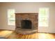 Bright living room featuring a stone fireplace, hardwood floors, and natural light from two windows at 695 Frog Rd, Locust Grove, GA 30248