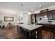 Modern kitchen features a spacious island with bar stools, dark cabinetry, and pendant lighting at 120 Westover Commons, Fayetteville, GA 30214