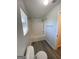 Bathroom features a shower-tub combo, a toilet, wood-look floors, and a window at 253 Whistle Way, Locust Grove, GA 30248