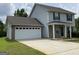 Charming two-story home featuring a gray siding, a two-car garage, and a well-maintained front yard at 253 Whistle Way, Locust Grove, GA 30248