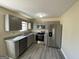 A kitchen with stainless steel appliances, gray cabinets, granite countertops, and wood-look vinyl floors at 253 Whistle Way, Locust Grove, GA 30248