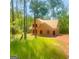 Exterior view of home in the woods under construction, showcasing exposed wood frame, set amidst lush greenery at 107 Oak Rd, Locust Grove, GA 30248