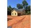 Detached garage with light yellow siding, complemented by a simple roof and surrounded by a cleared lot at 107 Oak Rd, Locust Grove, GA 30248