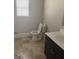 Clean bathroom features neutral-toned tile flooring, a dark vanity with light countertop, and bright natural light at 1124 Pebble Creek Ln, Locust Grove, GA 30248