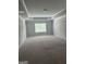 Spacious bedroom featuring tray ceilings and soft carpeting, illuminated by natural light from a window at 1124 Pebble Creek Ln, Locust Grove, GA 30248