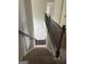 A carpeted staircase has dark wood railing at 1124 Pebble Creek Ln, Locust Grove, GA 30248