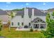 View of the home's backyard, showcasing a patio, screened porch, well-maintained lawn, and wooded surroundings at 19 Mediterranean Ave # 506, Sharpsburg, GA 30277