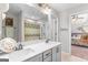 Bright bathroom with double vanity, shower with patterned curtain, and doorway to bedroom at 19 Mediterranean Ave # 506, Sharpsburg, GA 30277
