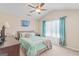 This bedroom features light tan walls, a ceiling fan, and a large window with blue curtains at 19 Mediterranean Ave # 506, Sharpsburg, GA 30277