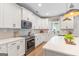 Bright kitchen with white cabinets, stainless steel appliances, quartz countertops, and tiled backsplash at 19 Mediterranean Ave # 506, Sharpsburg, GA 30277