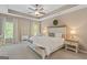Comfortable bedroom with neutral tones, tray ceiling, ceiling fan, and large windows providing natural light at 19 Mediterranean Ave # 506, Sharpsburg, GA 30277