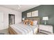 Well-lit bedroom with neutral carpet, dark accent wall, ceiling fan, and a comfortable bed with throw pillows at 604 Parnassus Rd # 05, Locust Grove, GA 30248