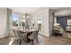 Bright dining room featuring a large window, modern chandelier, and access to the patio for outdoor dining at 604 Parnassus Rd # 05, Locust Grove, GA 30248