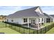 A home exterior featuring a well-maintained yard, black fence, and a covered patio area at 604 Parnassus Rd # 05, Locust Grove, GA 30248