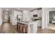 Modern kitchen with stainless steel appliances, white cabinets, large island with breakfast bar and wood flooring at 604 Parnassus Rd # 05, Locust Grove, GA 30248