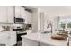 Well-appointed kitchen with stainless steel appliances, white cabinets, quartz counters, and a view to the dining area at 604 Parnassus Rd # 05, Locust Grove, GA 30248