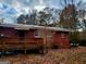 View of back brick home with deck surrounded by trees in the backyard at 309 Cornish Mountain Rd, Covington, GA 30014