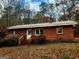 Charming brick home featuring classic architecture with a metal roof surrounded by trees at 309 Cornish Mountain Rd, Covington, GA 30014