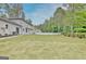 A full view of the backyard of a white home with light green lawn and white fencing at 400 Walnut Grove Rd, Peachtree City, GA 30269