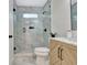 Modern bathroom featuring a glass-enclosed shower with marble tiling, a light wood vanity, and black hardware at 400 Walnut Grove Rd, Peachtree City, GA 30269