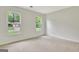 Bright bedroom with neutral carpet, white walls, and dual windows offering views of the neighborhood at 400 Walnut Grove Rd, Peachtree City, GA 30269