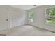 Neutral bedroom featuring a closet, neutral carpet, and natural light through windows with neighborhood views at 400 Walnut Grove Rd, Peachtree City, GA 30269