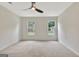 Bedroom showcasing neutral carpet, two windows providing natural light, and a modern ceiling fan at 400 Walnut Grove Rd, Peachtree City, GA 30269