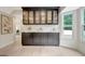 Bright dining area with custom black cabinetry, marble countertops and built-in glass shelving and oversized window at 400 Walnut Grove Rd, Peachtree City, GA 30269