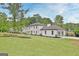 Exterior view showcasing the home's manicured lawn, gray roof, and attached garage at 400 Walnut Grove Rd, Peachtree City, GA 30269