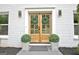Close-up of double doors decorated with wreaths and flanked by symmetrical green planters at 400 Walnut Grove Rd, Peachtree City, GA 30269