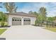 A detached two car garage with a concrete driveway sits behind a newly constructed home at 400 Walnut Grove Rd, Peachtree City, GA 30269
