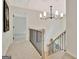 Bright hallway with carpeted floors, a modern chandelier, and staircase access to other floors at 400 Walnut Grove Rd, Peachtree City, GA 30269