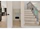 Hallway with a staircase, under-stairs storage, hardwood floors, and modern black and white finishes at 400 Walnut Grove Rd, Peachtree City, GA 30269