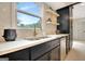 Kitchen sink with custom black cabinets, marble countertops, tile backsplash and open wood shelving at 400 Walnut Grove Rd, Peachtree City, GA 30269
