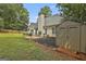 Exterior of home with spacious backyard, patio, shed, and lush landscaping at 215 Murphy Creek Ln, Fayetteville, GA 30215
