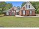Charming brick home with manicured lawn and mature trees offers classic curb appeal at 215 Murphy Creek Ln, Fayetteville, GA 30215